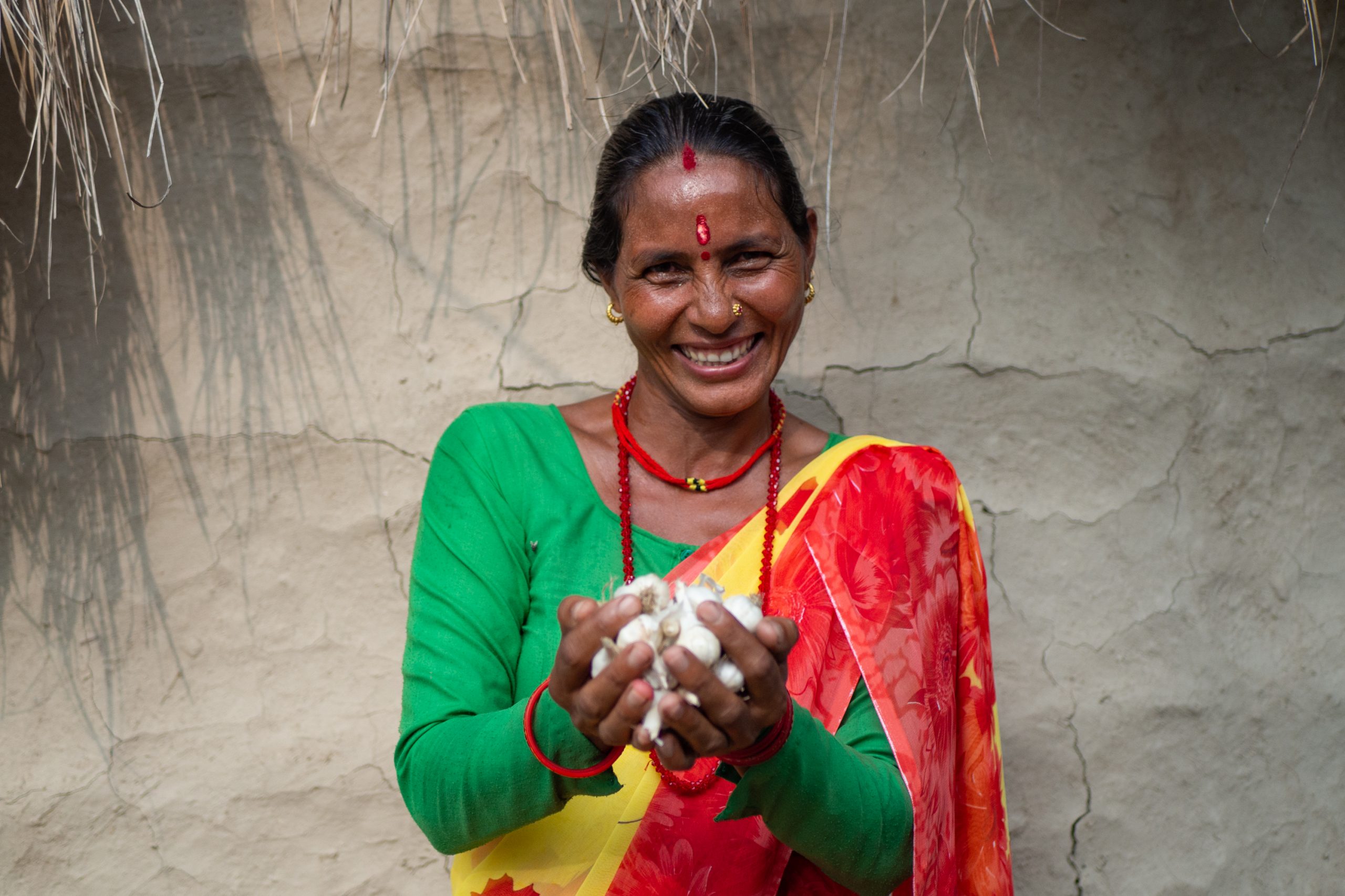 Bimala Devi Bhatta holds garlic grown by members of her community’s women’s group.