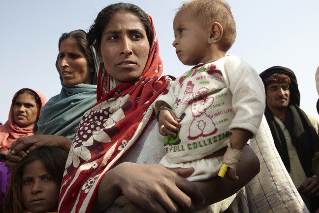 Photo: Andy Hall/Oxfam Homeless farm labourer Husna Molbudh with her malnourished and sickly son Manawar (1). Shabaz camp for displaced people outside Hyderebad, Sindh province. Photo: Andy Hall/Oxfam