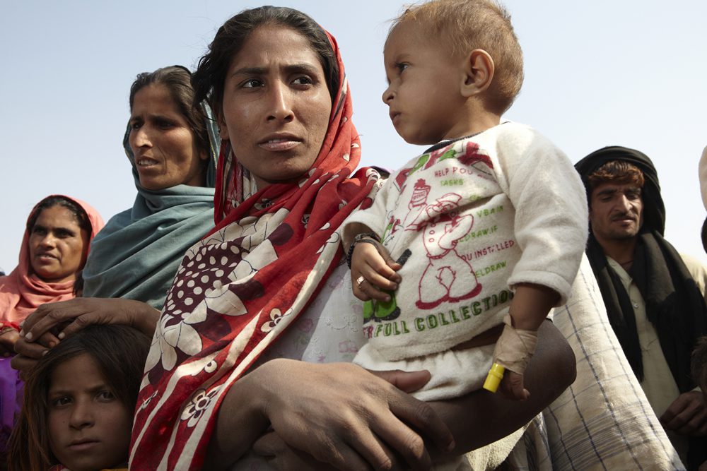 Homeless farm labourer Husna Molbudh with her malnourished and sickly son Manawar (1). Shabaz camp for displaced people outside Hyderebad, Sindh province. Photo: Andy Hall/Oxfam