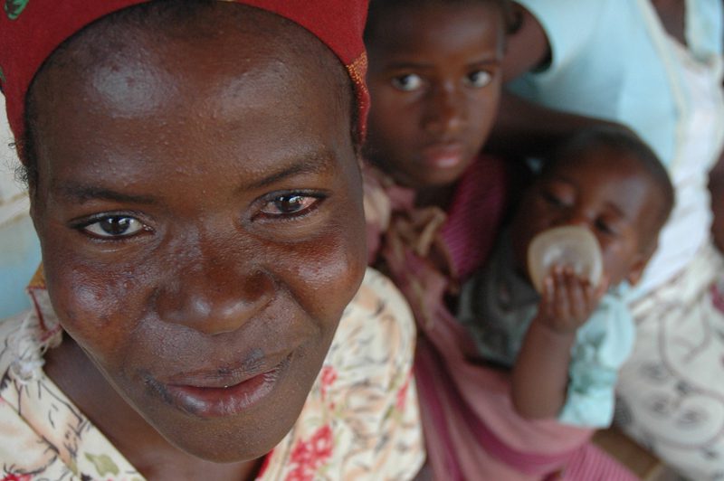 Close up of a woman's face with children in the background