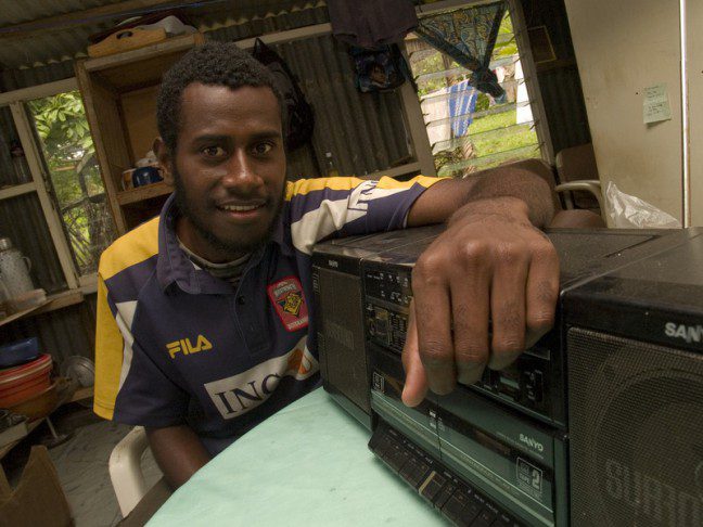 Kency Bang (at his home in the Black Sands community, Port Vila) listens to Famli blong Sera, a radio show produced by the Wan Smolbag Theatre to raise awareness about issues such as HIV and AIDS, reproductive health and good governance.
