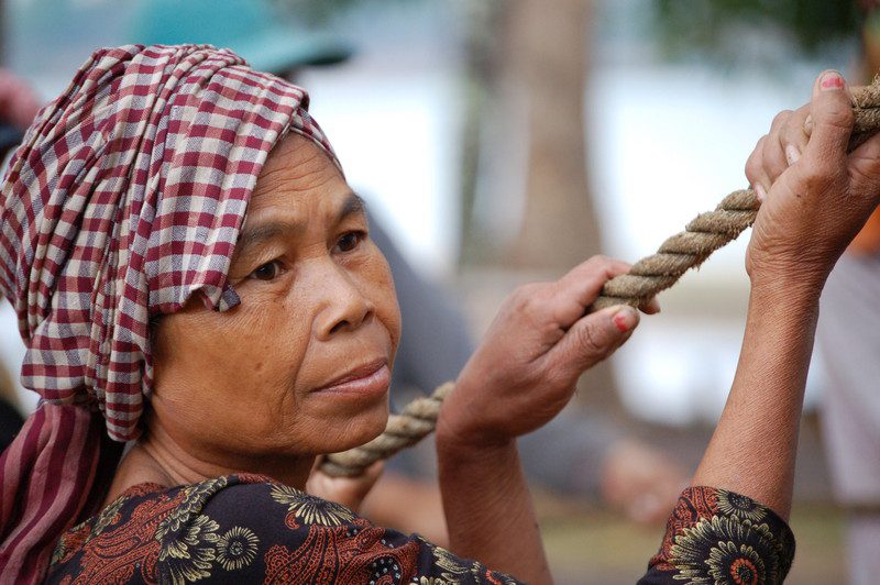 A woman helps raise the walls of her community's new rice bank. Photo: Maureen Bathgate/OxfamAUS