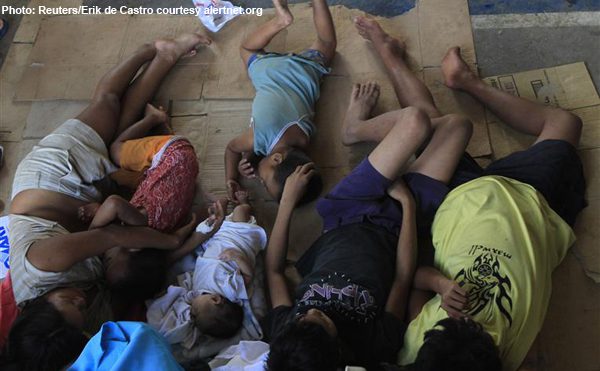 Typhoon Washi victims who are made homeless after their houses were swept away by flash floods rest at an evacuation center in Cagayan de Oro in the southern Philippines December 18, 2011. Rescuers searched for more than 100 people still missing in the southern Philippines on Sunday after flash floods and landslides swept houses into rivers and out to sea, killing almost 500 people in areas ill-prepared to cope with deadly storms. The cities of Cagayan de Oro and nearby Iligan on Mindanao island were worst hit when Typhoon Washi slammed ashore while people slept late on Friday and early Saturday, sending torrents of water and mud through villages and stripping mountainsides bare. REUTERS/Erik De Castro (PHILIPPINES - Tags: DISASTER ENVIRONMENT SOCIETY)