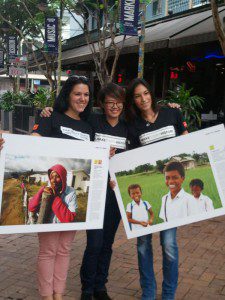 Oxfam volunteers Brie (left) and Yoko (right) team up with café manager Jackie Lui for an MX photo shoot to promote the exhibition. Photo: Ann Matson/OxfamAUS