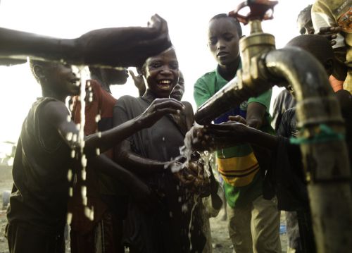 Photo: Kieran Doherty/Oxfam Emmanuel Ekai (8) and other children collect fresh water from the borehole to drink as it's piped out for the first time. Photo: Kieran Doherty/Oxfam