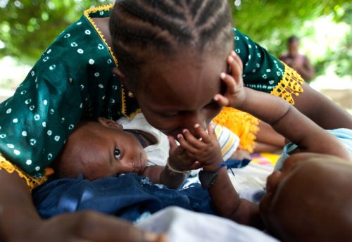 Photo: Holly Pickett/Oxfam Though they have no mother of their own, orphaned twins at the feeding center receive kind attention from a caregiver. Photo: Holly Pickett/Oxfam
