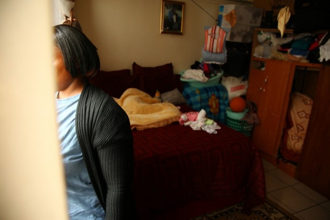 Teresa gets ready for a day at her home-based childcare centre. Her face is obscured to protect her identity. Photo: Matthew Willman/OxfamAUS