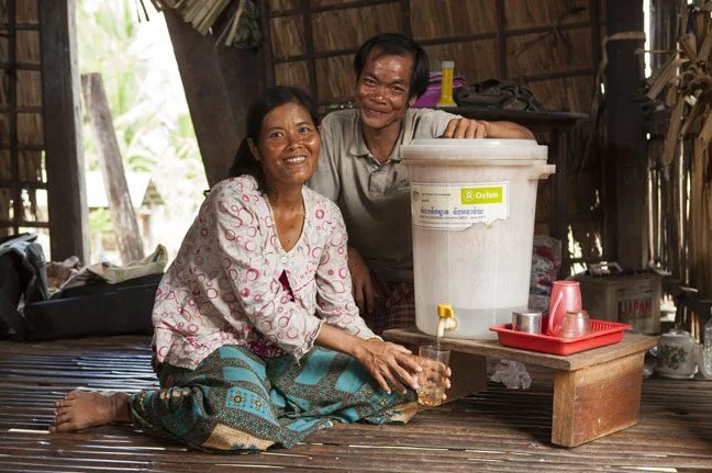 Mr Khvan Ry, 41yrs and Mrs Van Sineth, 37yrs, village hygiene promoter use a water filter provided by Oxfam, Kratie Province, Cambodia. Photo: Timothy Herbert/OxfamAUS 58565lpr-648px