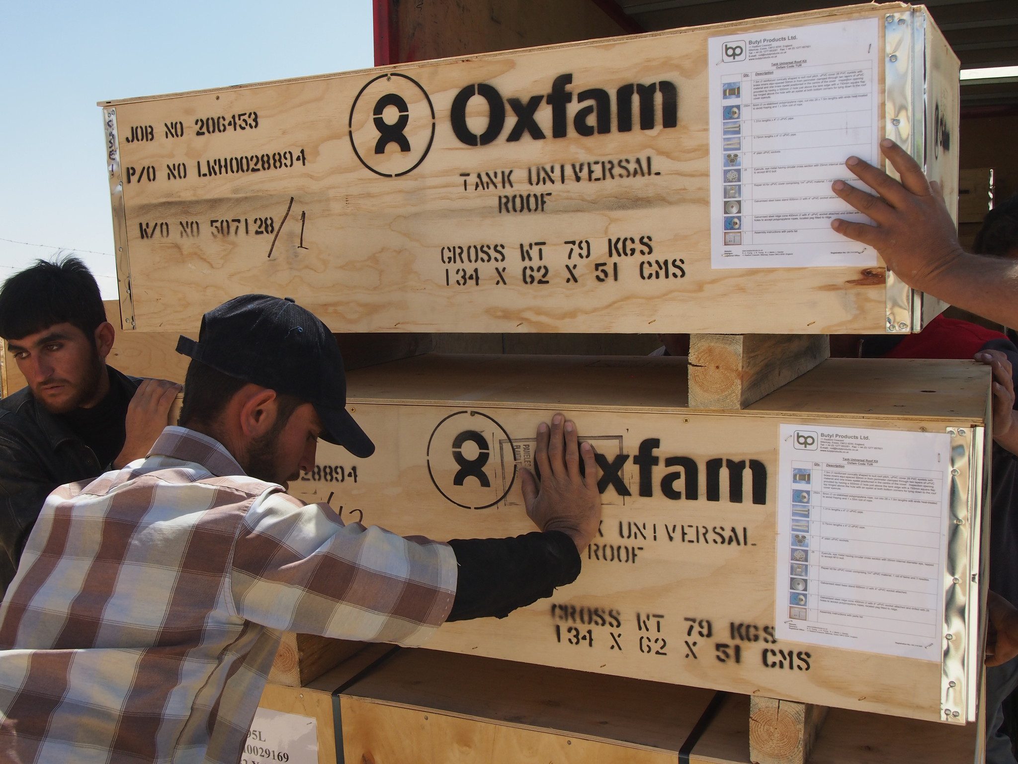 Oxfam team unloading wooden crates containing 13 T95 tanks (can hold 95,000 litres of water) being delivered to the Oxfam warehouse in Zaatar. Photo: Caroline Gluck/Oxfam