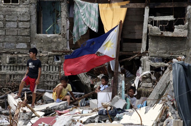 Philippino children stand in the rubble of houses in super typhoon devastated town Hernani, eastern Samar province, Philippines, 11 November 2013. Photo: EPA/DENNIS M. SABANGAN