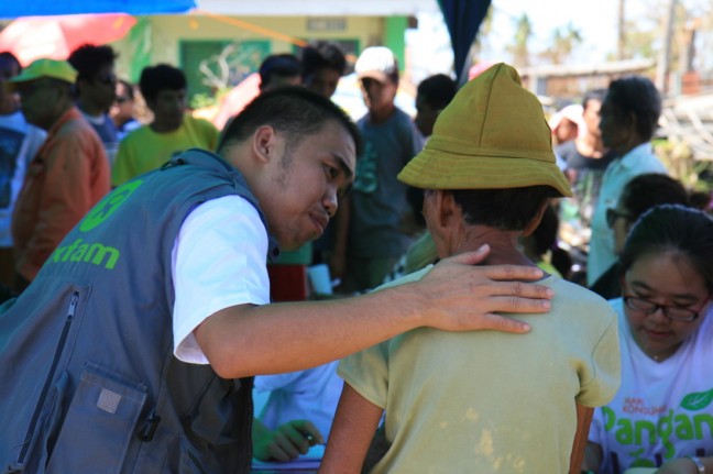 Vincent Malasador gives support and reassurance to recipient during the distribution of hygiene items in Paypay north Cebu Photo: Jane Beesley/Oxfam