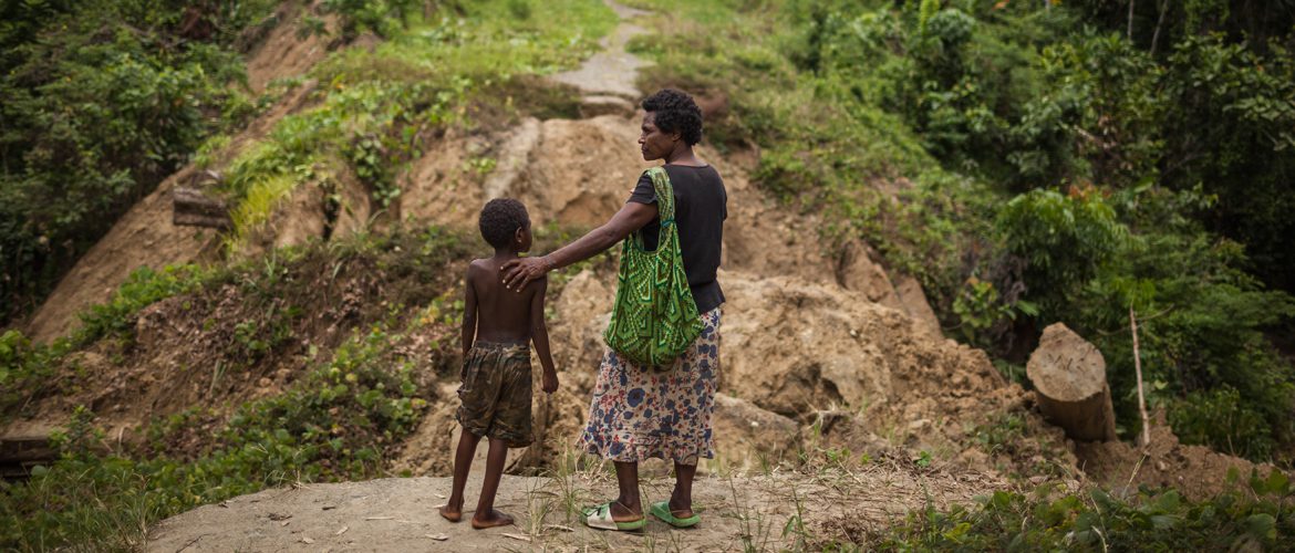 Aunty and nephew stand near a collapsed logging bridge in Papua New Guinea