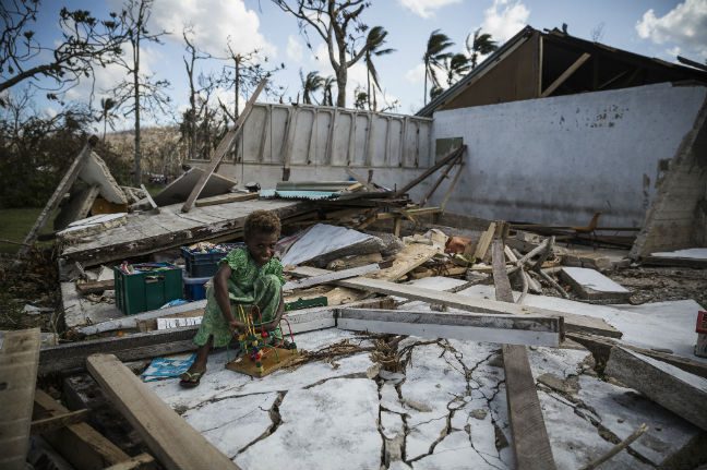 Leitare, 7, playing on the remains classroom of the Epau village Primary School. The classroom was build apart from the main school building and was completely destroyed by Cyclone Pam. Photo: Vlad Sohkin/OxfamAUS Cyclone Pam and climate change