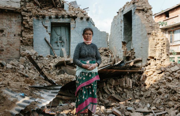 A Nepal earthquake survivor stands in the rubble of her home