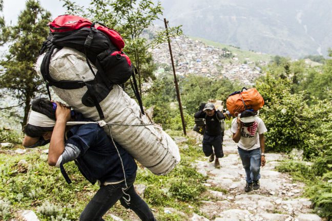 36 porters hired by Oxfam to deliver relief material by foot. The road is inaccessible due to recent landslides. The village of Laprak can be seen in the background. Photo: Sam Spickett Nepal earthquake donations