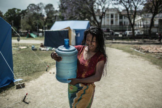 A woman carrying water in the Tundikhel IDP camp.