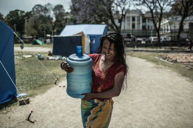 A woman carrying water in the Tundikhel IDP camp.