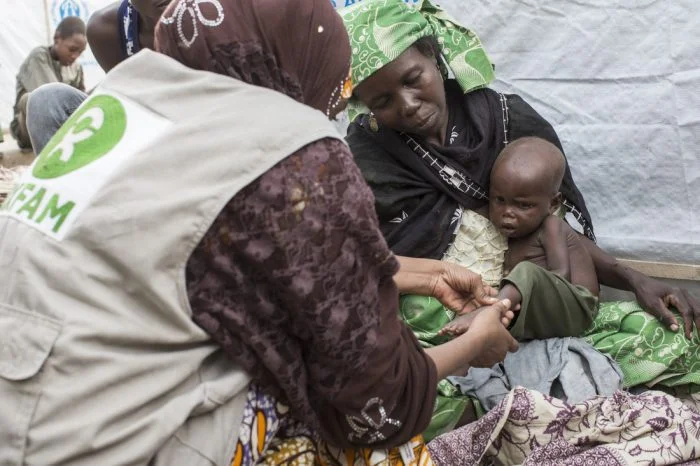An Oxfam protection officer inspects Aamin*, who is 2years old and badly malnourished as he sits with his mother Aisha* in Nigeria. *Names have been changed to protect identities. Photo: Sam Tarling/Oxfam