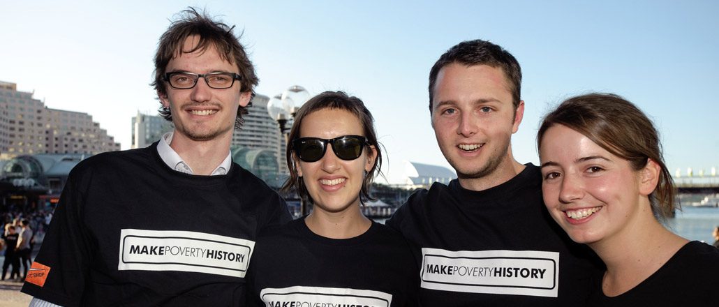 4 people smiling, wearing Make Poverty History Tshirts