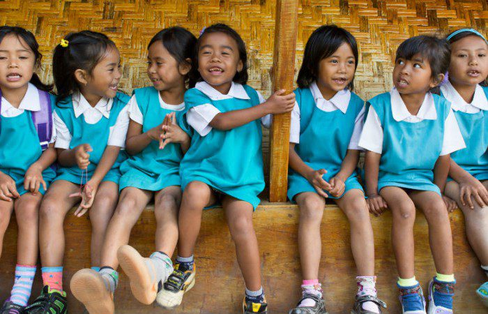 School girls sing a song to welcome visitors to the 'reading corner' set up by the village preparedness and response team in Sembalun Lawang, Indonesia.