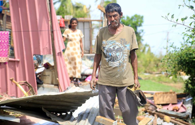 Photo: Adi Kautea Nacola/Grasskirt Photography/OxfamAUS A man stands defeated in the remants of his home in the aftermath of Cyclone Winston in Fiji