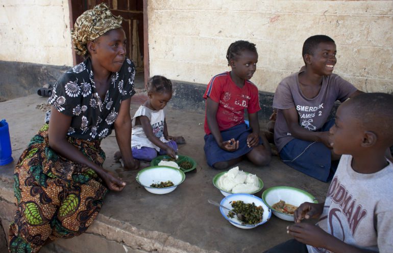 Photo: Abbie Trayler-Smith/Oxfam Irene and her children enjoy a meal together outside their home in Zambia, Africa.