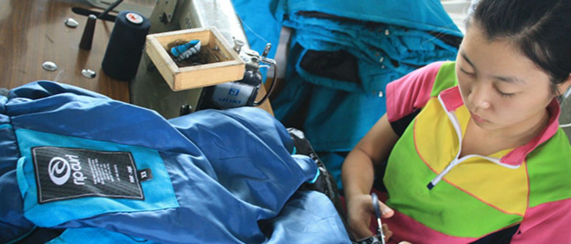 A woman works on a Rip Curl Jacket in North Korea