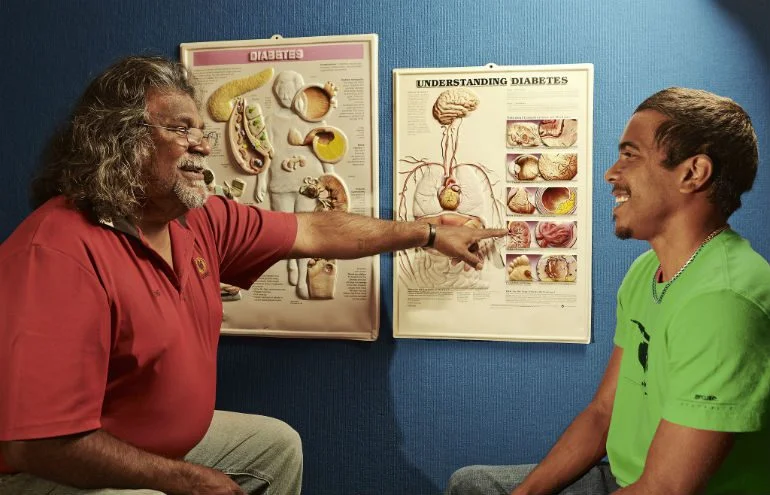 Here, Geraldton Aboriginal Health worker, Eric Dalgety, speaks with a young client, Kane. Photo: Jason Malouin/Oxfam AUS.