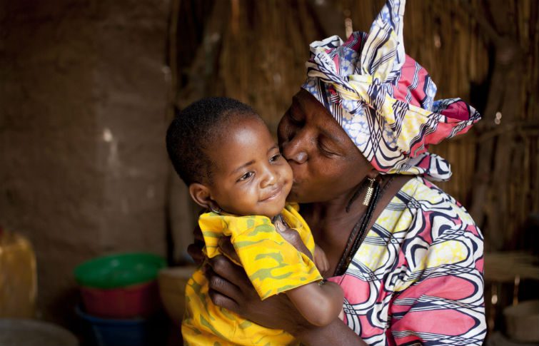 A lady kisses a child on the cheek