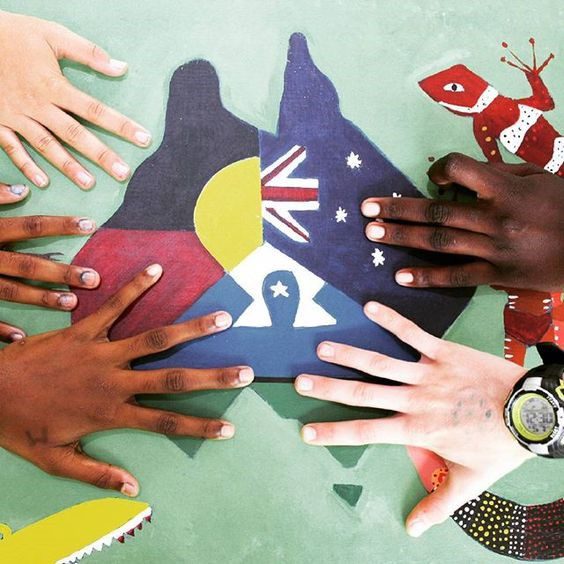 Photo: Rosie Douglas/ Instagram @mtstbernard Indigenous and non-Indigenous hands rest on a map of Australia comprising the Australian, Aborginal and Torres Strait Islander flags.
