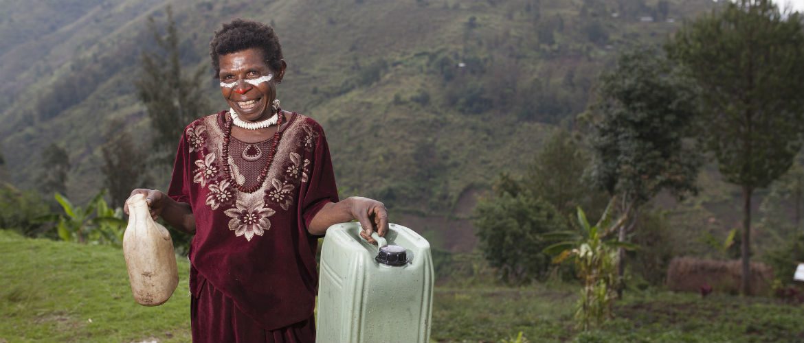 Marie holds her water container that she received from Oxfam