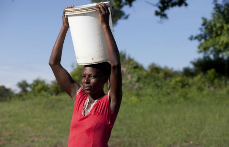 Ida with water bucket in Zimbabwe