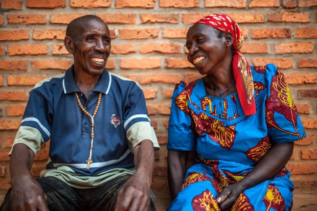 Kirehe district, Rwanda: Theresie takes a break from farming with her husband oustide their house in Eastern Rwanda. Photo: Aurelie Marrier d’Unienville/Oxfam. Kirehe district, Rwanda: Theresie takes a break from farming with her husband oustide their house in Eastern Rwanda. Photo: Aurelie Marrier d’Unienville/Oxfam.