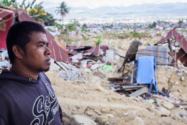 Photo: Andri Tambunan/Oxfam Portrait of Ronald (32) in front of his father's car repair shop in Palu. Ronald's father was killed when he a was swallowed by a sinkhole after a 7.4 magnitude earthquake hit off the coast of Palu, Sulawesi, Indonesia on Sept. 28th causing a tsunami.