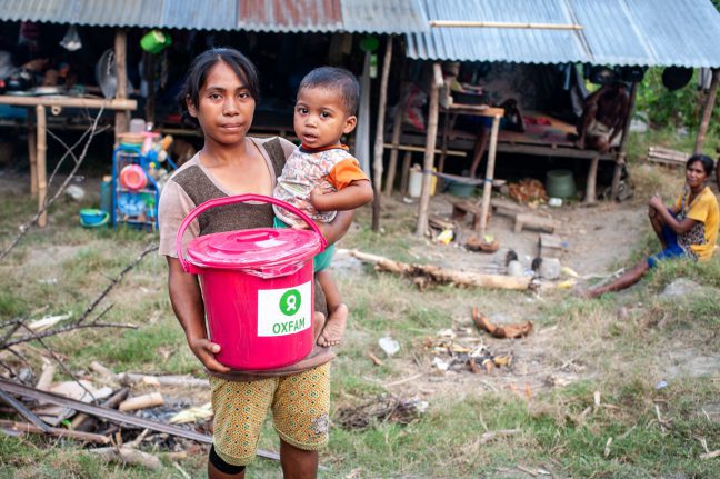 Afrianti and her son receiving hygiene kit in Palu, Indonesia after the recent earthquake and tsunami