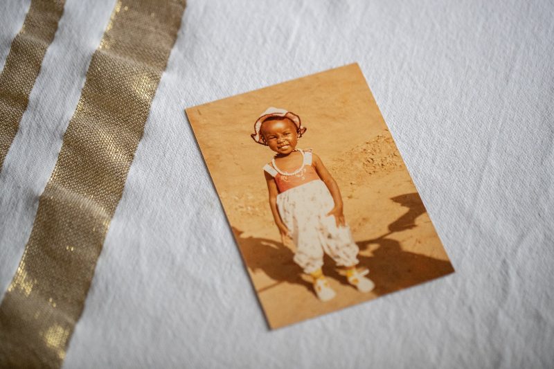 Melbourne, Australia: An old photo of Lucy’s daughter, Susan, taken before they were separated in Sudan. Photo: Kim Landy/Oxfam Australia An old photo of a child sits on a table.