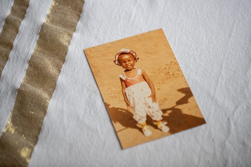 An old photo of a child sits on a table. 