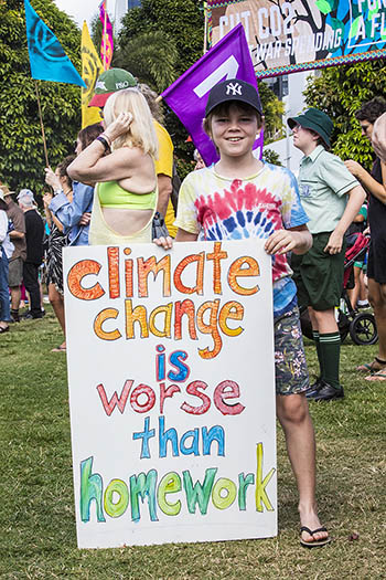 Young boy with a colorful #Climatestrike placard - Climate Change is worse than homework!