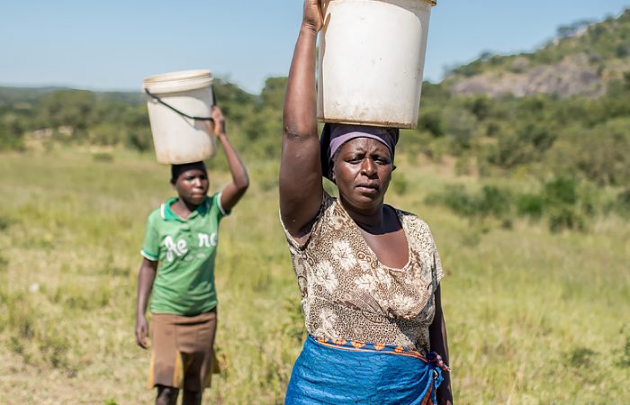 Enya collecting water with her child