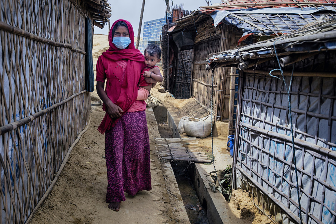 <p>Nur Jahan* with her daughter Ismat* is walking through the narrow alley beside her tent. Rohingya refygee camp. Cox's Bazar, Bangladesh</p>