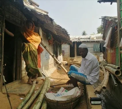Gender-related messages are disseminated through an Oxfam Bluetooth audio kit at a tea stall in the Cox’s Bazar refugee camps. During the COVID-19 pandemic, while door-to-door visits have been limited, these devices are providing essential information to communities. Umme Tamima/Oxfam Man sitting in refugee camp