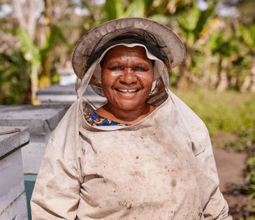 A bee farmer collects honey from her hives