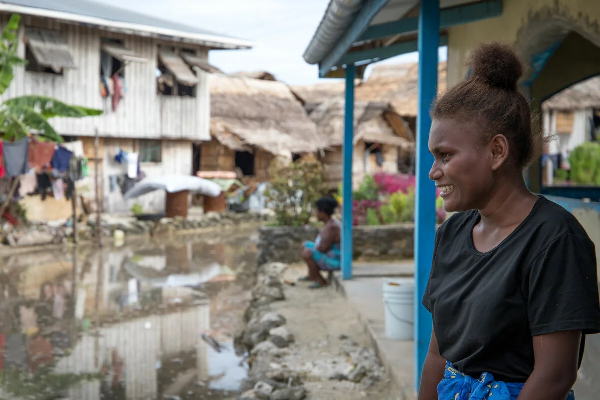 Lilisiana, Malaita Province, Solomon Islands: Grace Namoi (19), a student at the local high school, walks through water left in the town square after a high tide. Grace worries about the future of her town with the visible impacts of a changing climate.