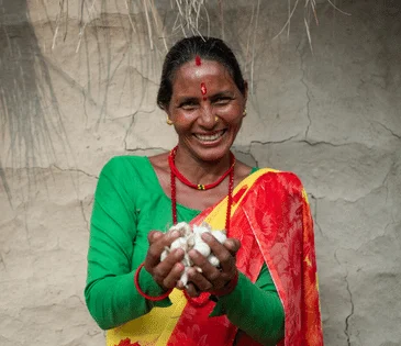 Nepal: Bimala Devi Bhatta holds garlic grown by members of her community’s women’s group.