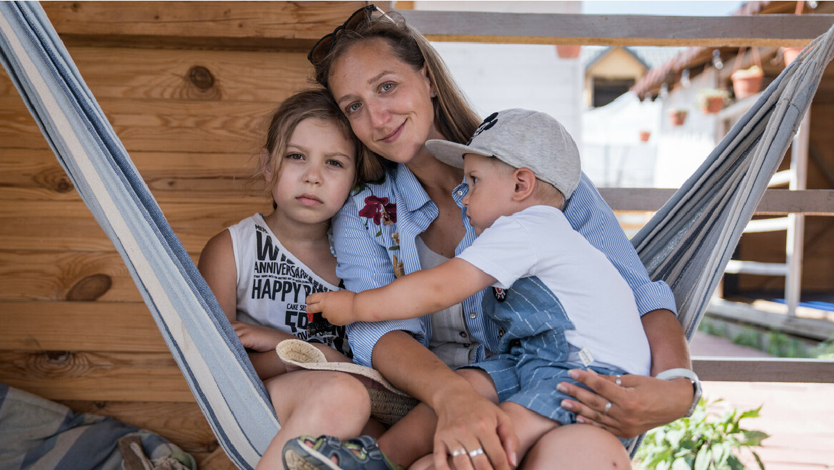Katerina, a 34-year-old Ukrainian refugee from Odessa, together with her son Miron*, 2 and her daughter Daria*, 8, in the backyard of the Bronx People Association, August 3rd, 2022. *Name changed to protect identity
