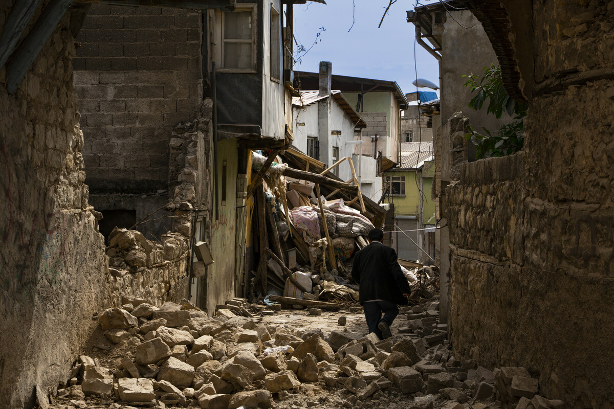 Turkiye: After the earthquake, most of the old houses in the neighborhood were destroyed. A man walks over the rubble trying to reach his house. Photo: Yalcin Ciftci/Oxfam KEDV