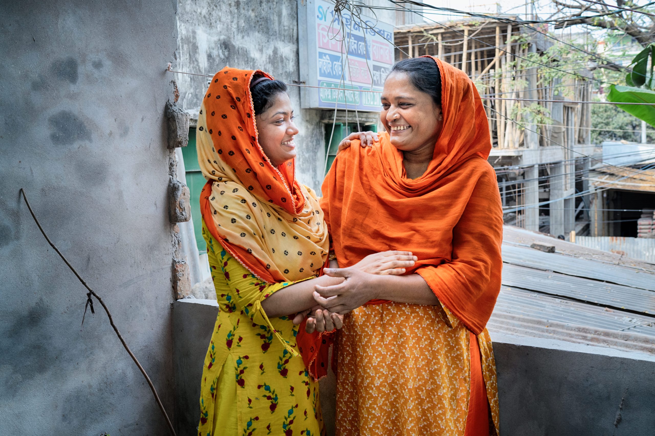 Kakoli* is spending time with Sabina. 23 years old Kakoli* lives alone since she started working in the garment factory. She hardly can send money to her parents living in village. She cuts yarn with a target of cut 120 yarns in an hour. With a 8970 Taka salary she hardly can manage her basic needs. Dhaka, Bangladesh Photo: Fabeha Monir/Oxfam