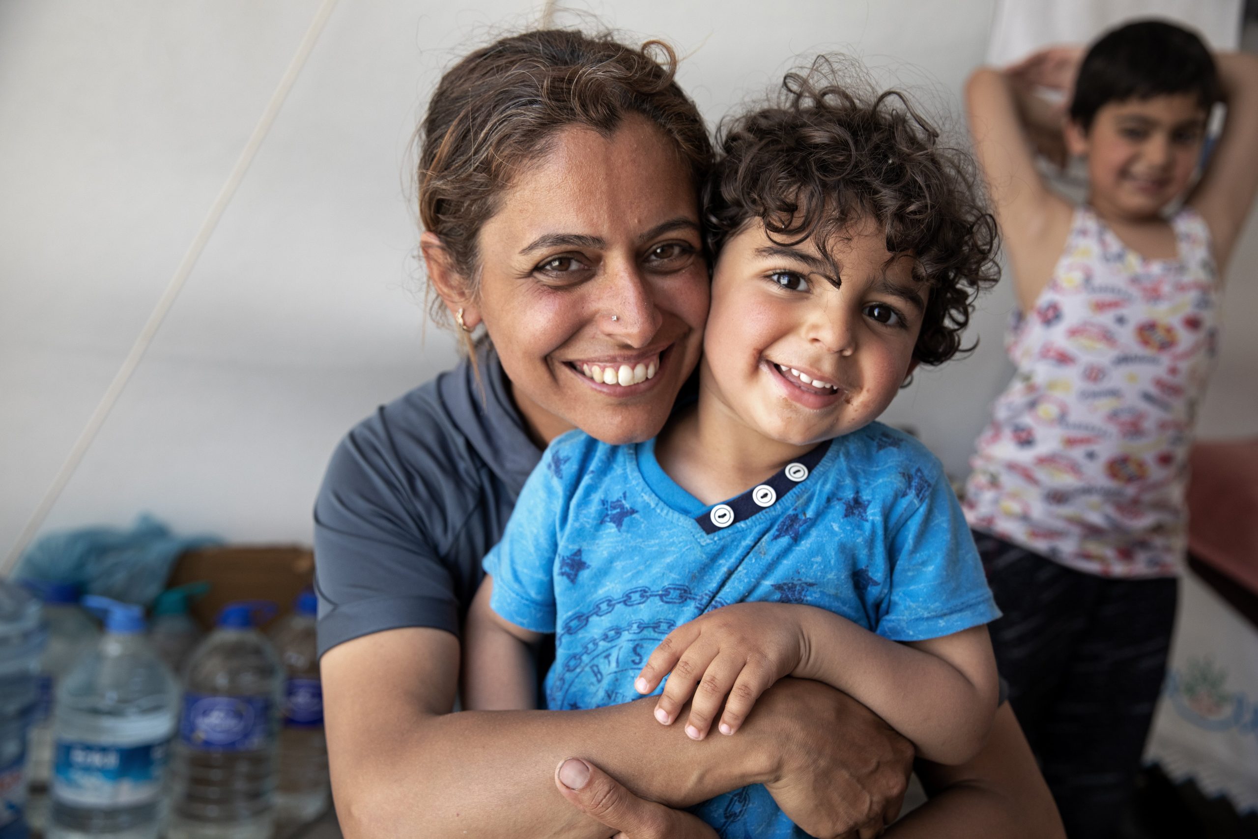 Turkiye: Mother and her two children are sitting in their tent. Photo: Delizia Flaccavento/Oxfam.