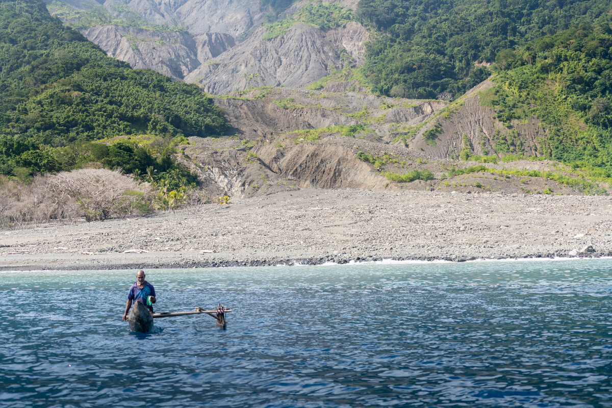 Roy fishes off the coast of his home, Molpoe village in Vanuatu. Molpoe was hit by a devastating landslide caused by climate change in 2022, which destroyed many homes and plantations that the people relied on for their livelihoods. Loss and Damage Vanuatu - Roy in his fishing boat