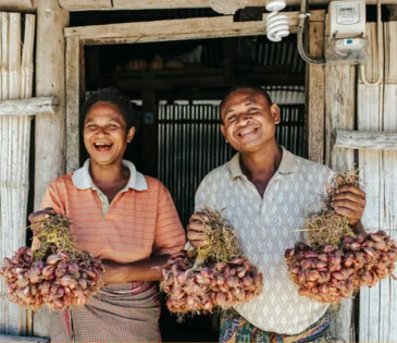 Oecusse, Timor-Leste: Sabina Foni and Mateus Elo hold the fruits of labour in their permanent garden. The couple said their harvest is significnatly increased since working with Oxfam. Photo: Kate Bensen/OxfamAUS